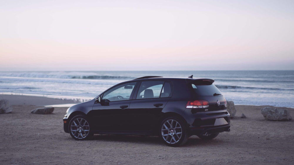 black car parked on the beach road