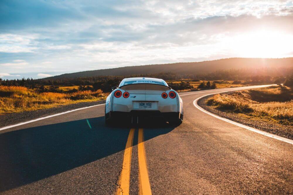 white car on the road during the sunset