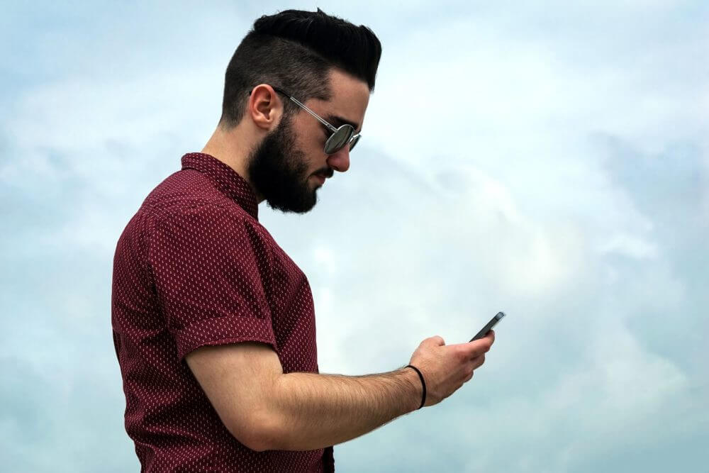 a guy typing on a phone