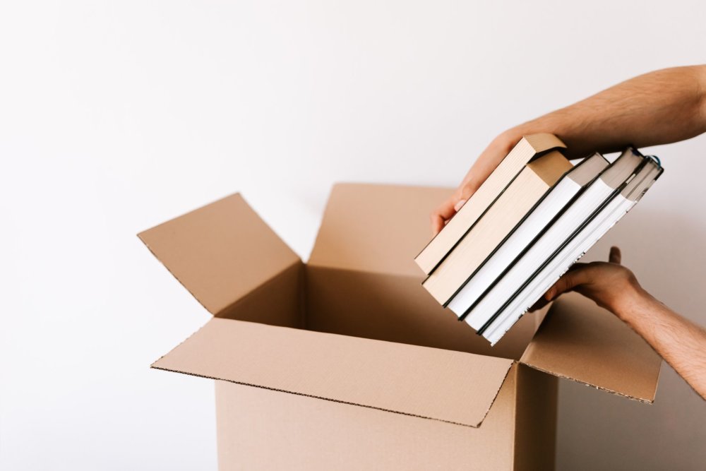 a man is packing books for a long-distance moving