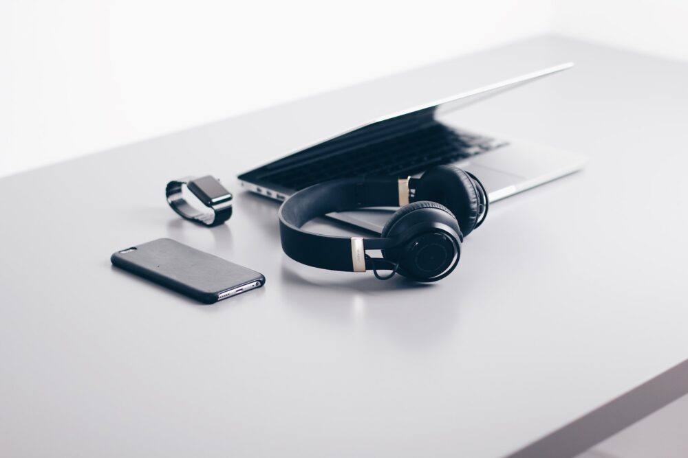 laptop, headphones, mobile and smart watch on the table