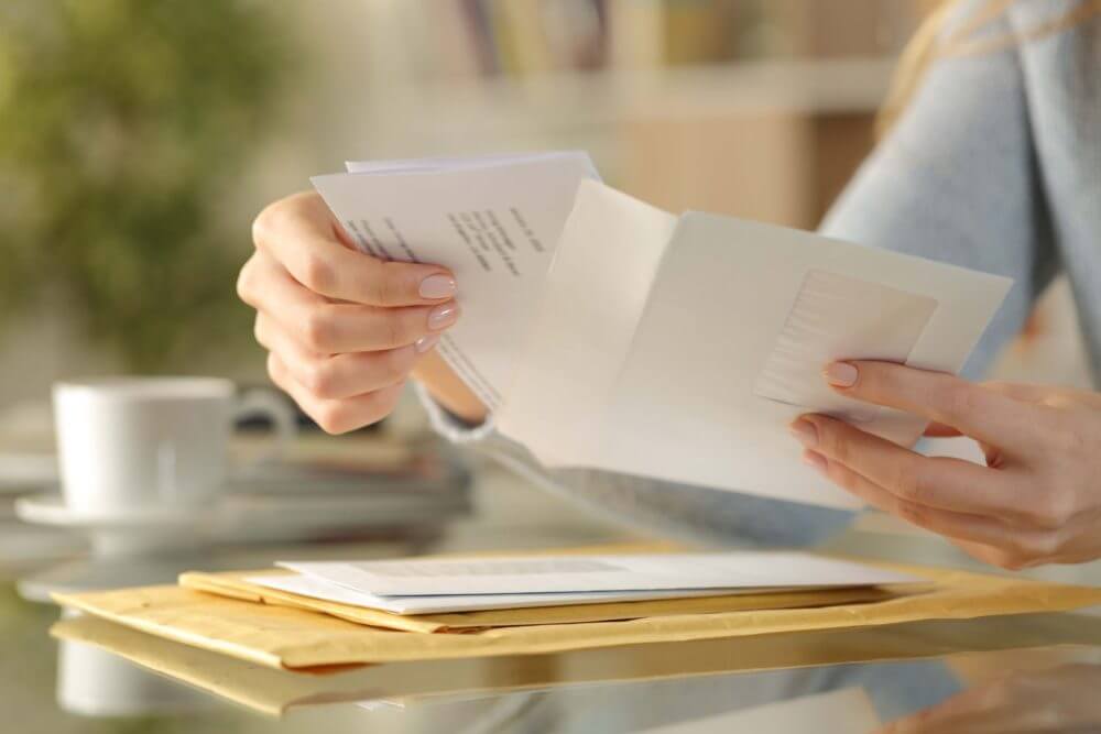 person sitting and opening mail