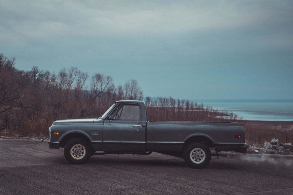 old grey pick up truck parked by the beach