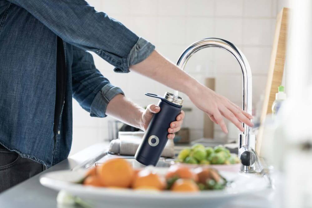 person filling a water bottle