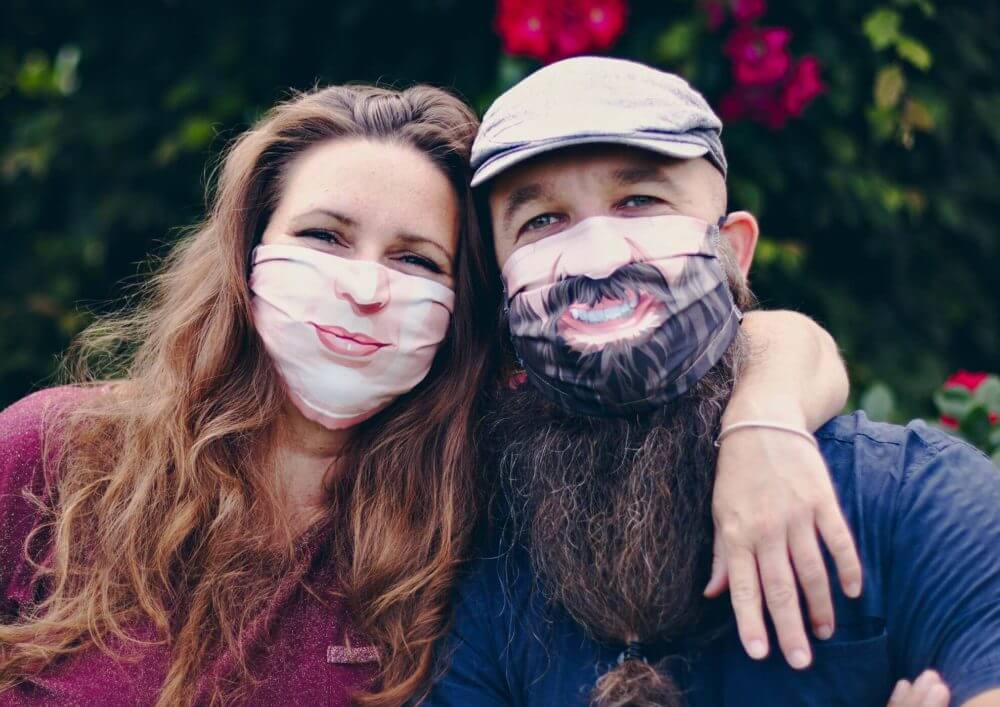 couple with happy face masks protecting themselves from covid 19