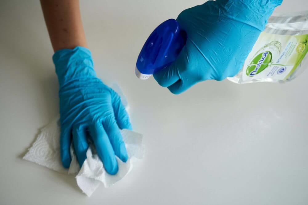 person cleaning table because of covid 19