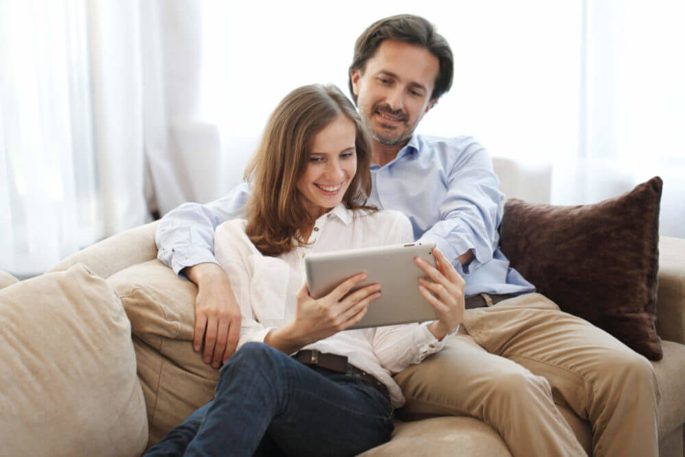 man and woman looking at tablet 