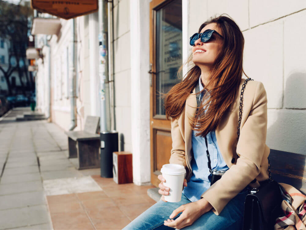 Smiling woman is drinking coffee