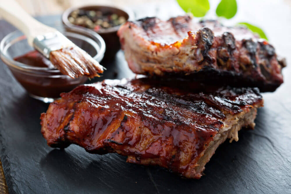 Barbecue chuck beef ribs with hot marinade as top on a wooden cutting board