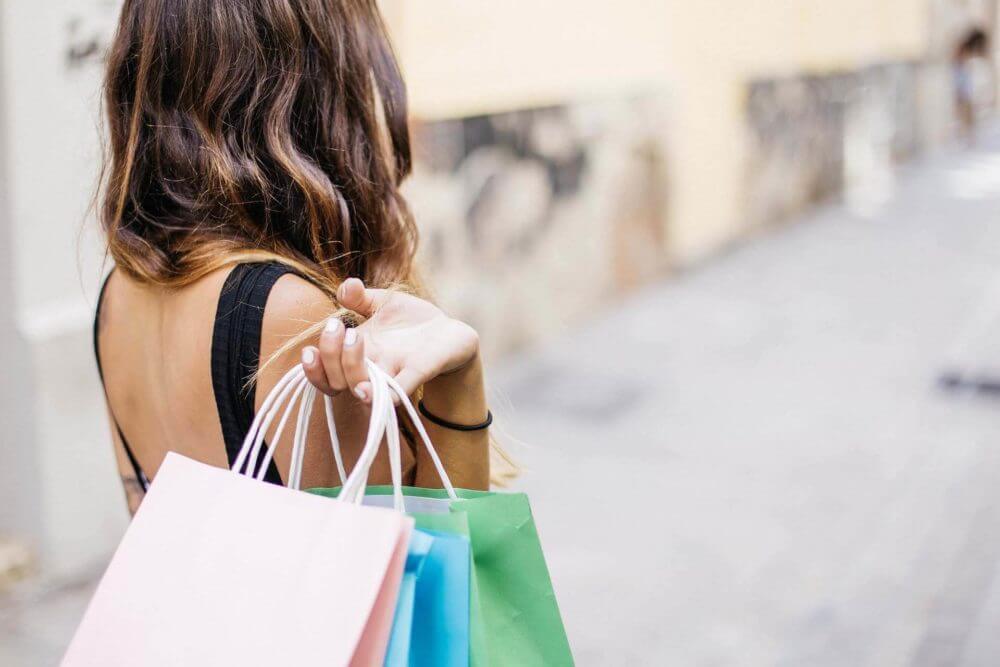 girl carrying many shopping bags