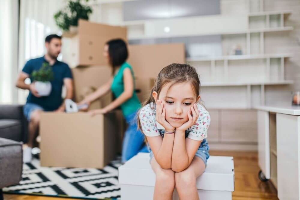 kid sitting while parents are packing