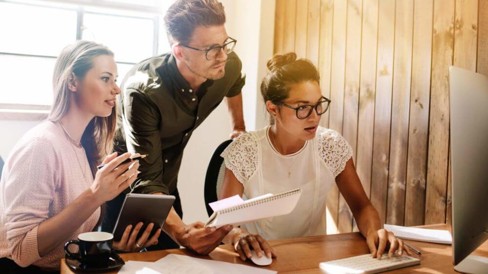 three people working on computer