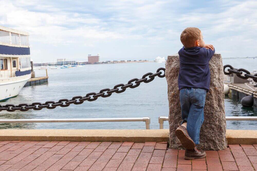 boy in harbor. little kid looking at ships and sea