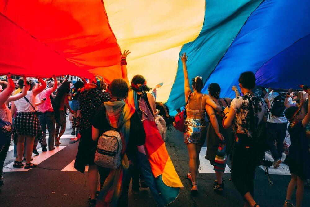 people under the rainbow flag
