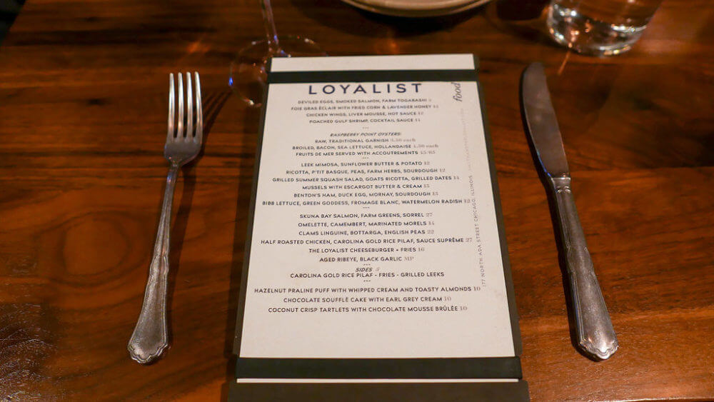 The menu with cutlery on wooden table