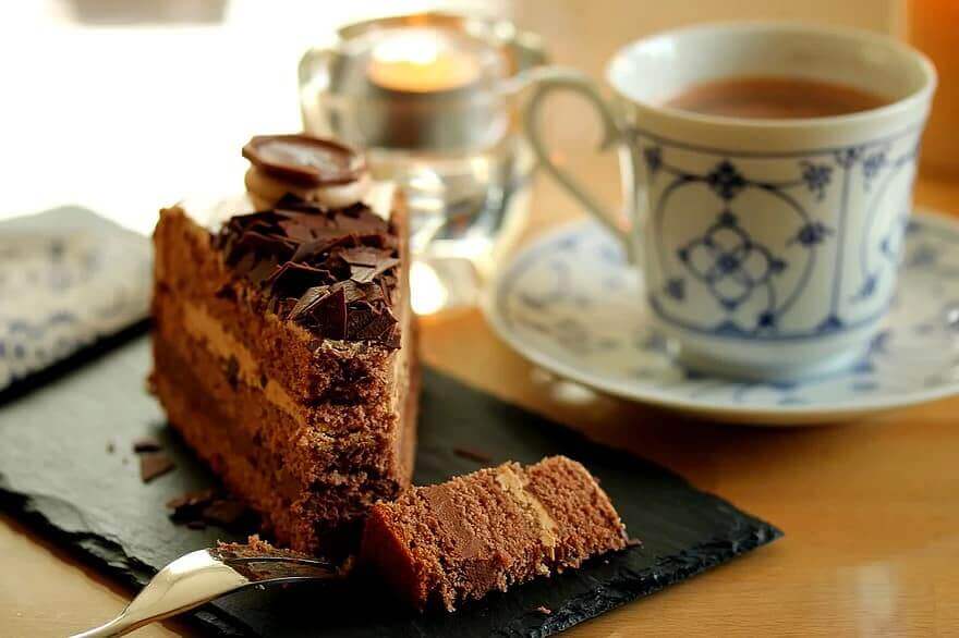 Sweet cake with cup of tea on wooden table