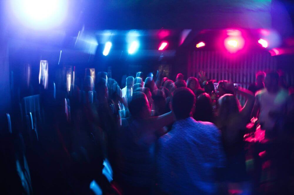 A lot of people standing and dancing in front of a concert stage