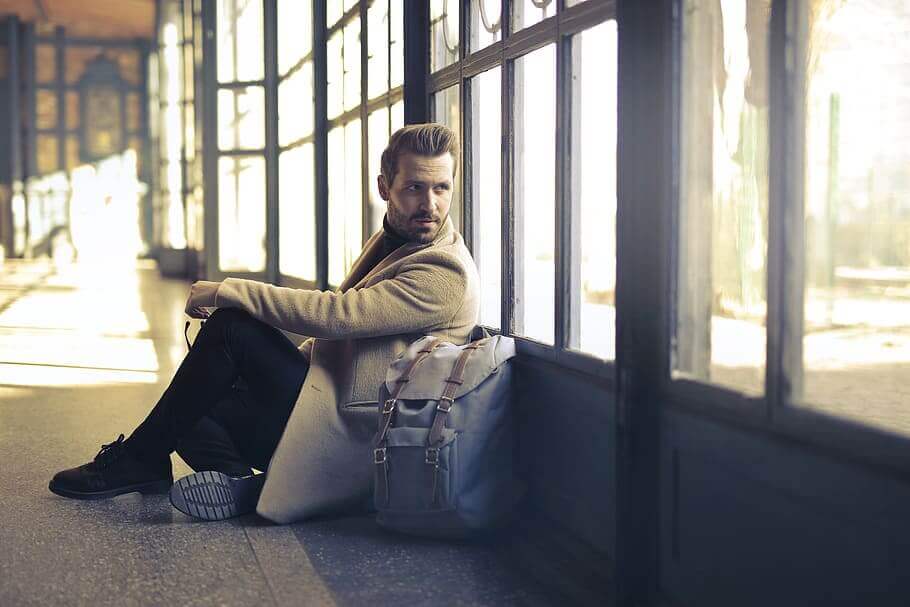 A man sitting on the floor and looking back through the window