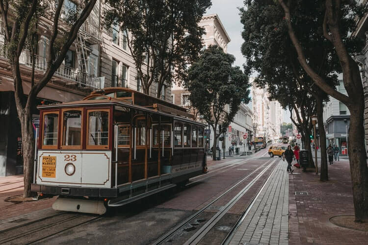 Cable car parked near trees