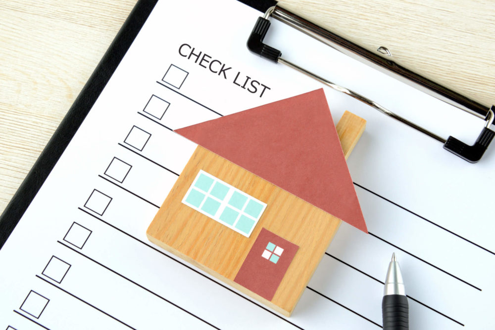 model of a house on a checklist 