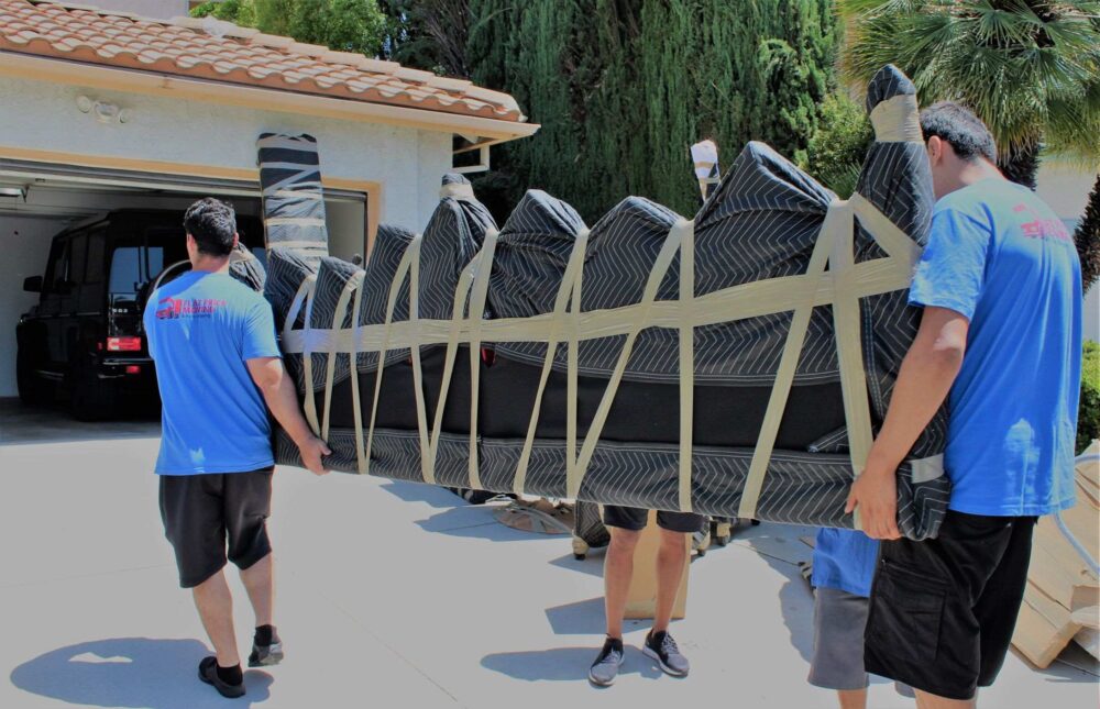 A long-distance moving company carrying a sofa