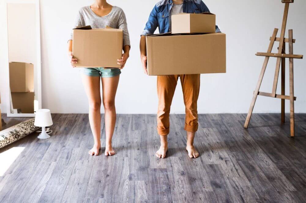 couple holding boxes in a room