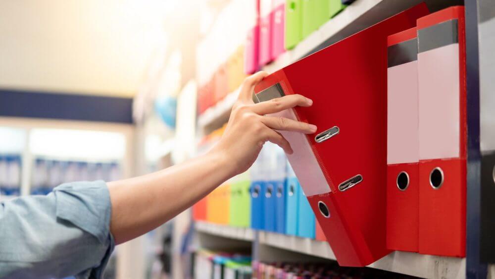 Man putting folder on a shelf