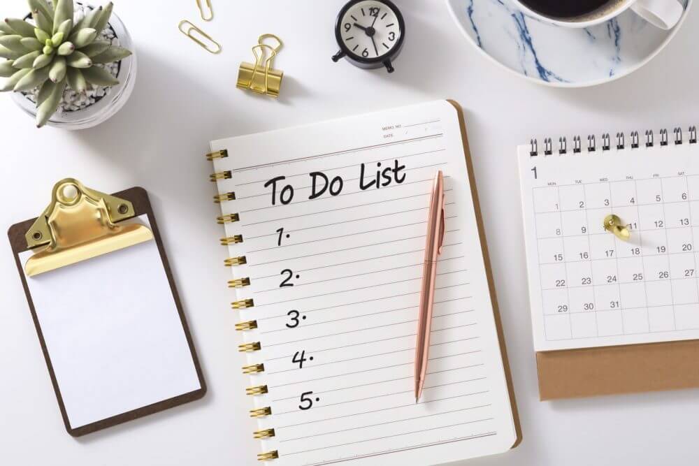 A to-do list and a pen on a white desk