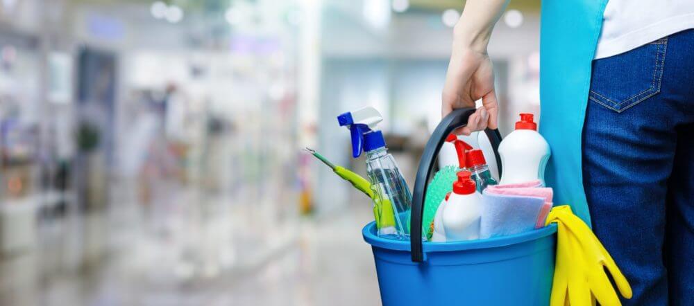 person holding a bucked filled with cleaning supplies