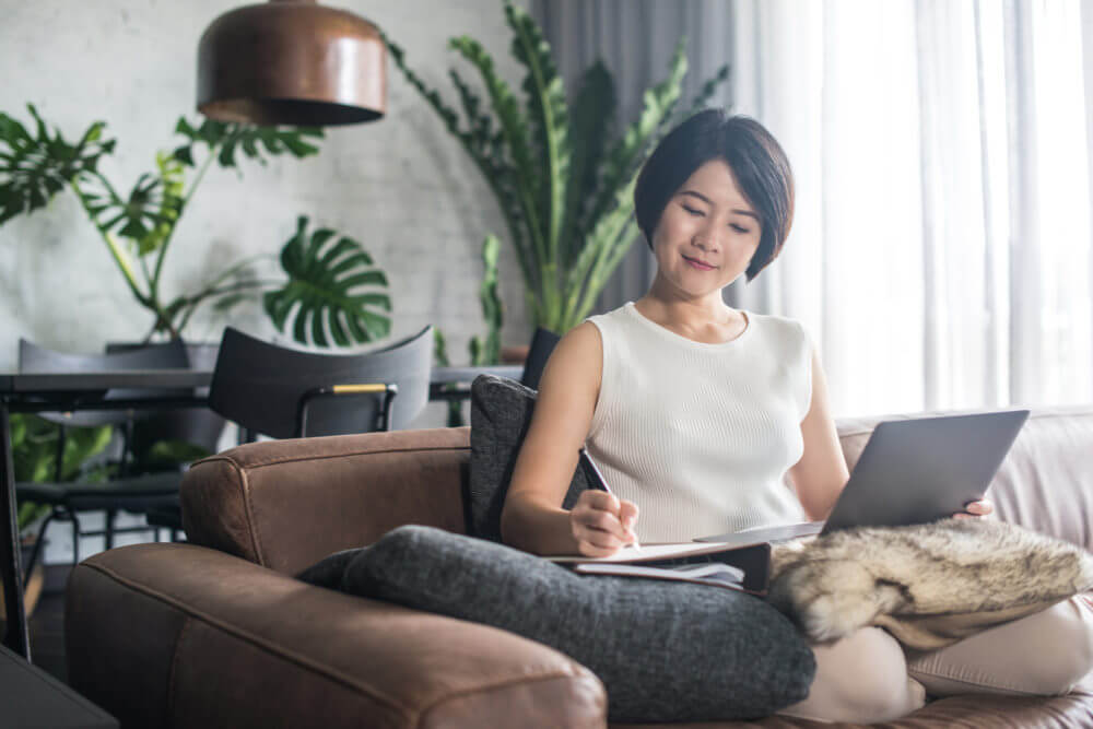 Woman sitting on the couch and working on a computer