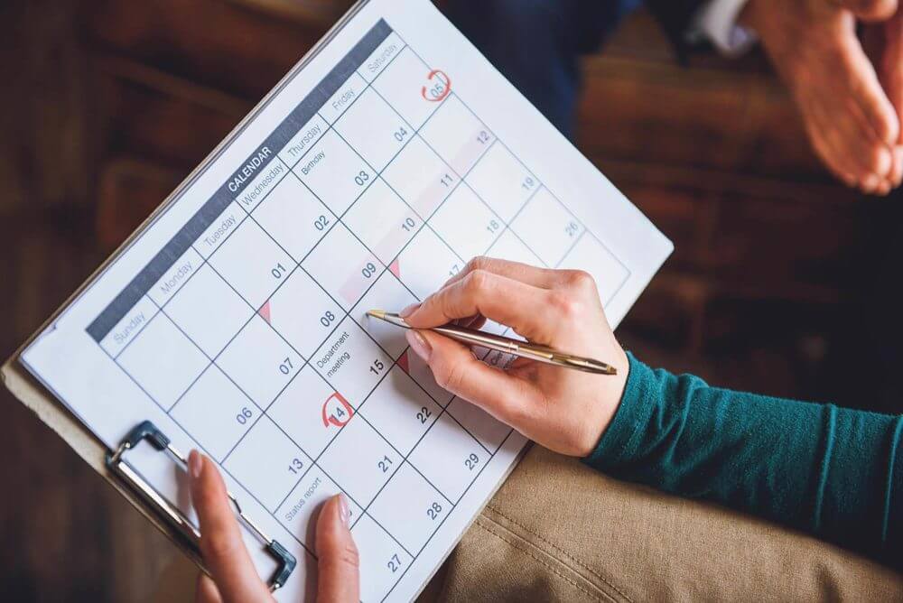 A person writing down in a calendar