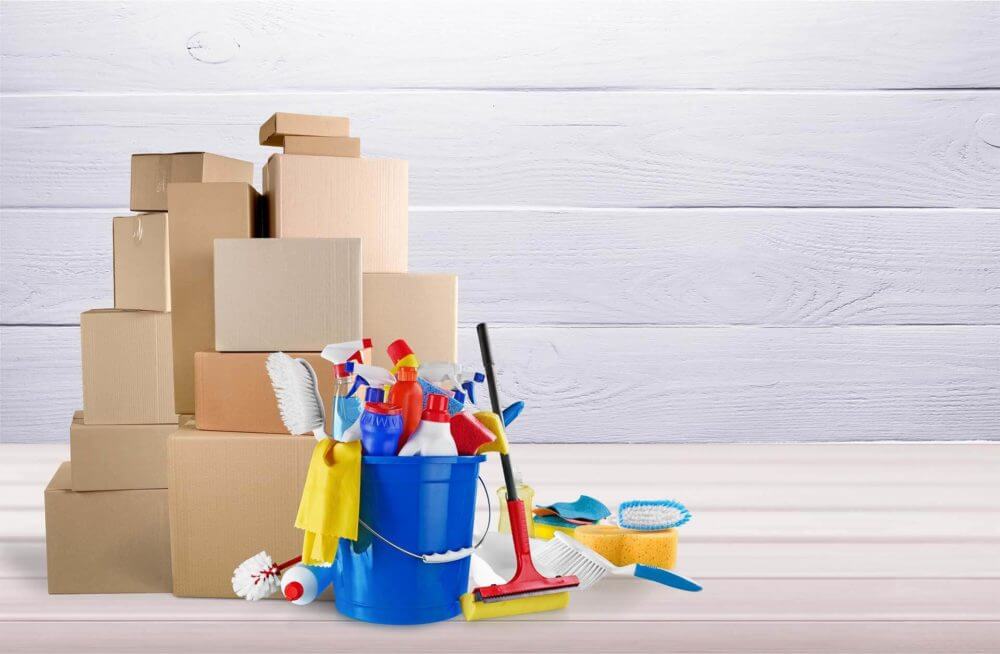 Cleaning supplies in a bucket and boxes on the floor 