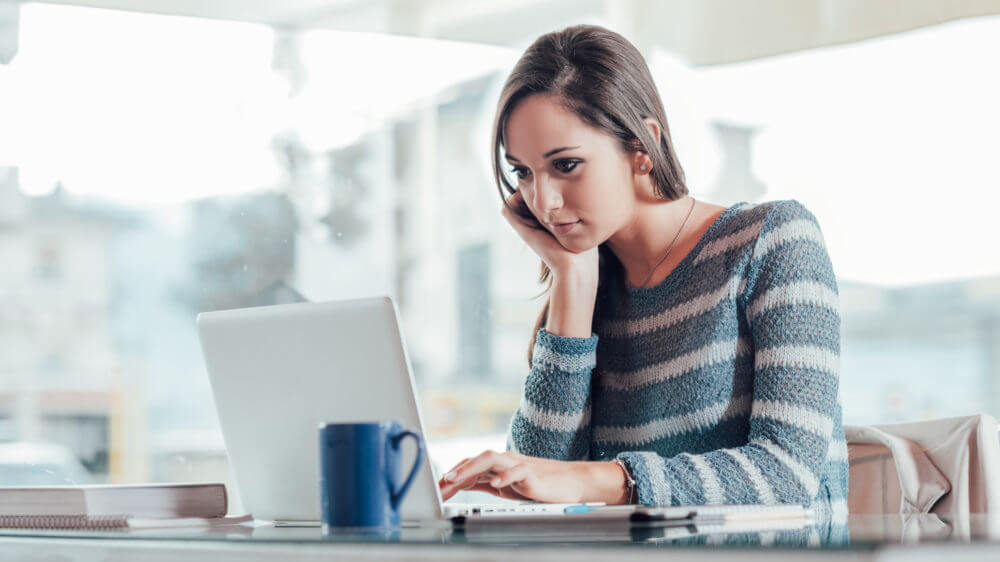 Busy young woman working with her laptop on a desk