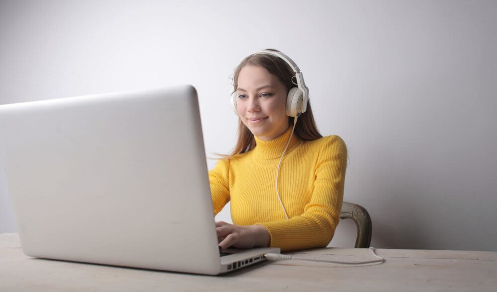 Woman with headphones on a computer