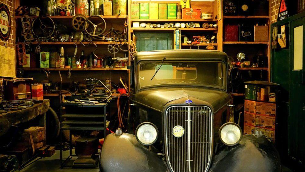 A garage with a car and many objects stored on shelves