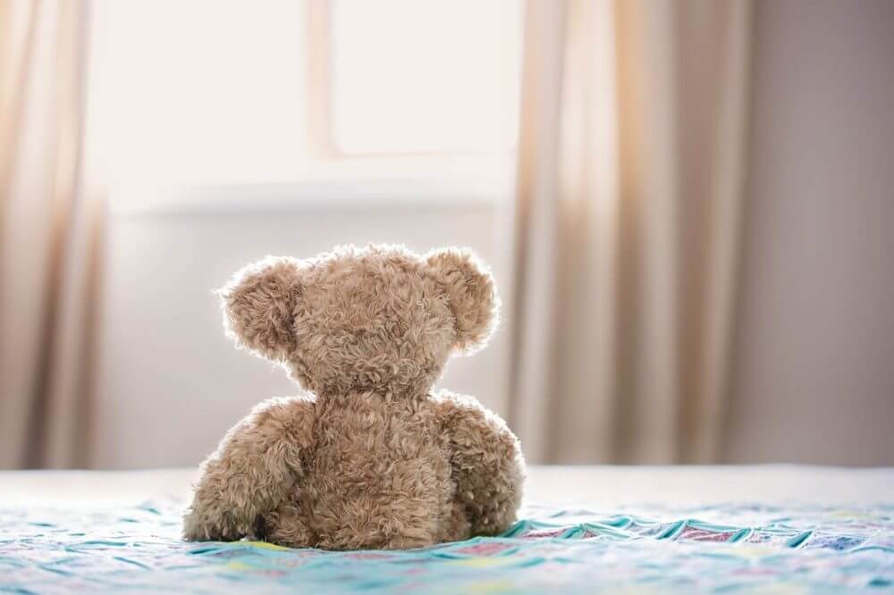 Plush teddy-bear on a bed