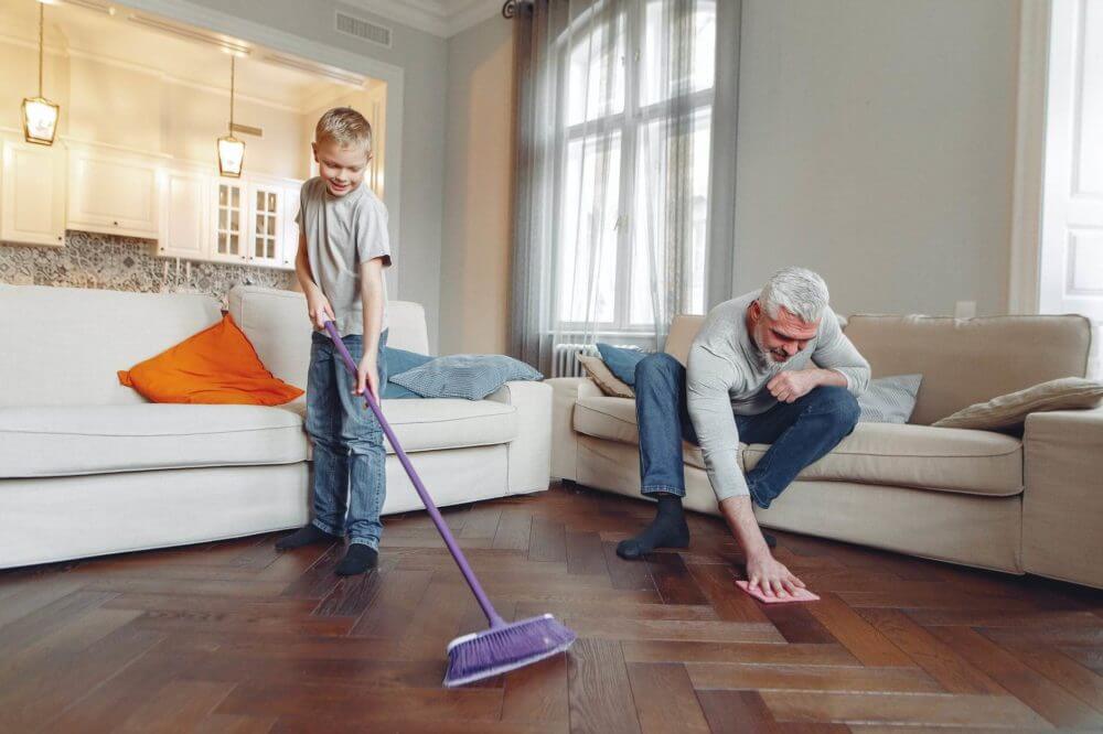 A man and a child cleaning their wood flooring