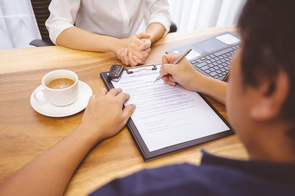 two people signing papers