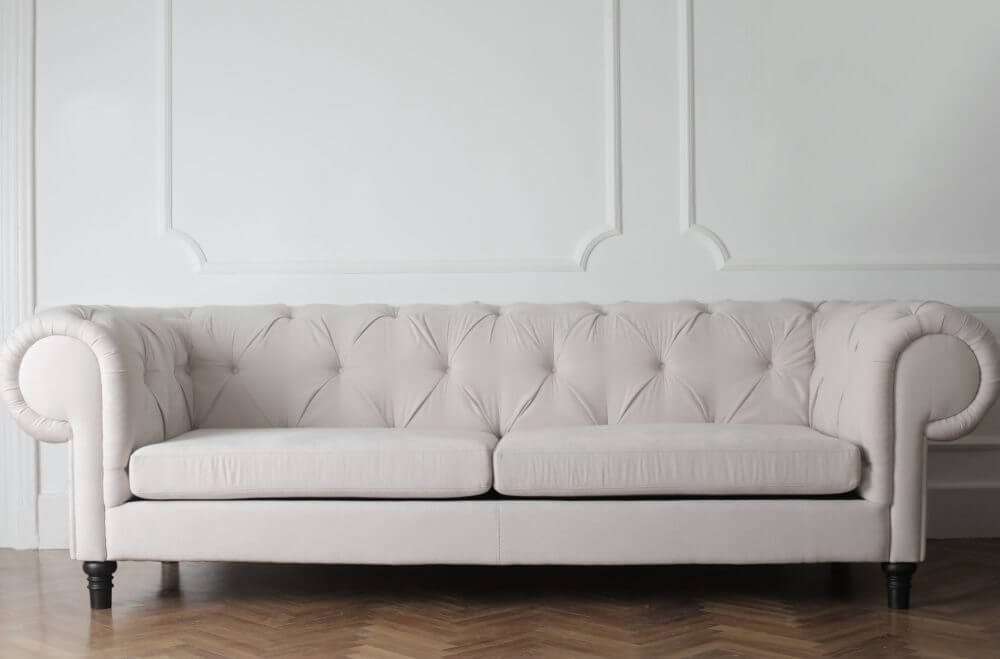 A white couch reassembled by cross-country movers