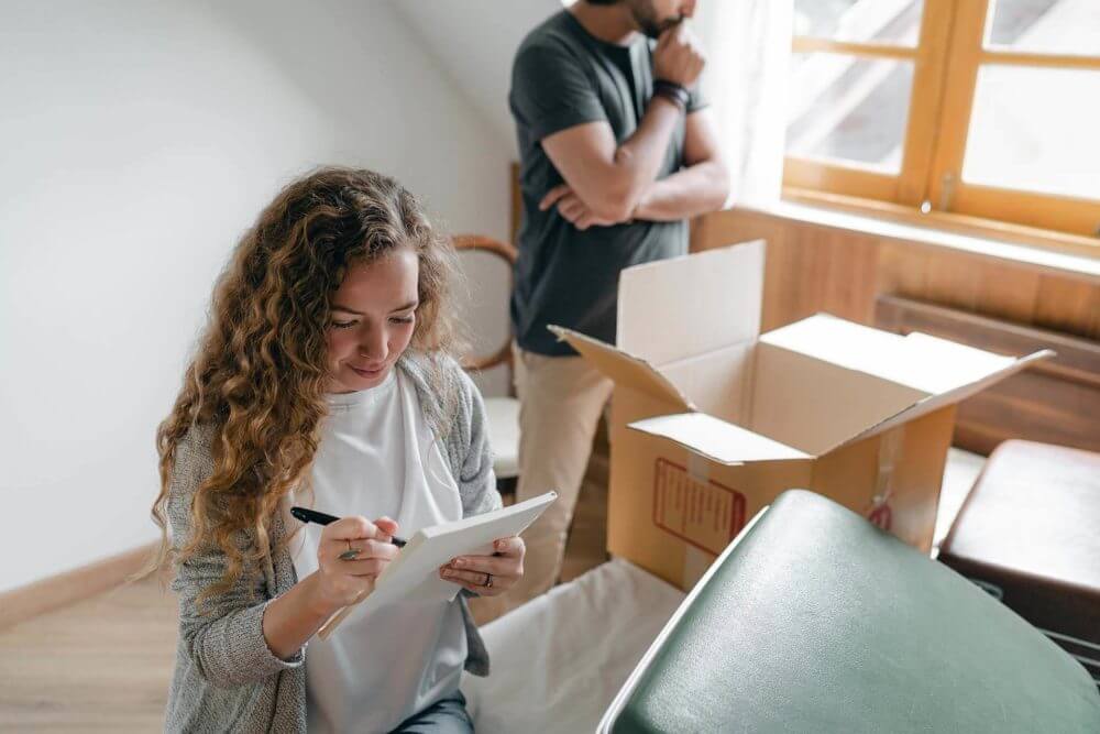 A woman holding a checklist and a man behind her