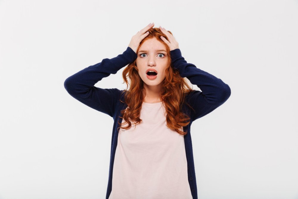 A woman holding her head, worried about cross-country moving