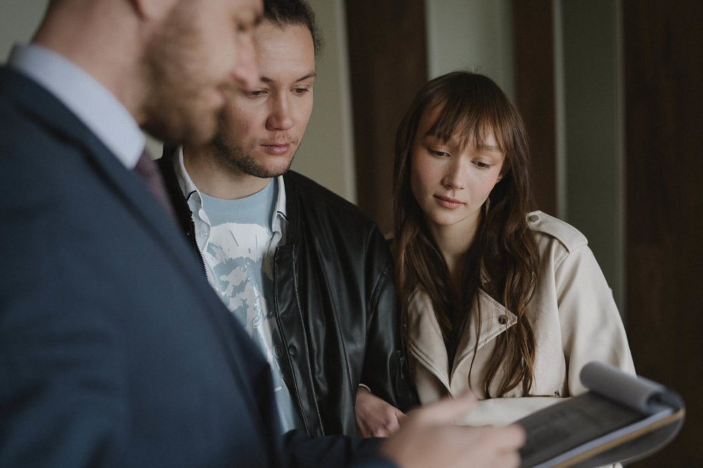 A man and a woman discussing with a realtor  