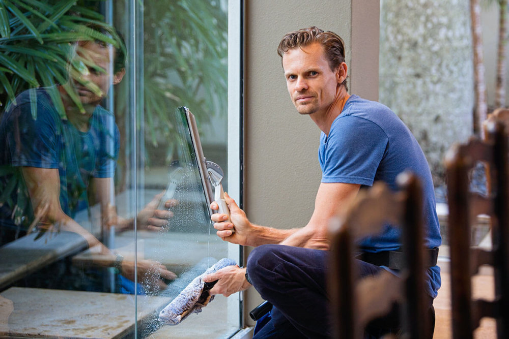 A man cleaning windows after cross country moving