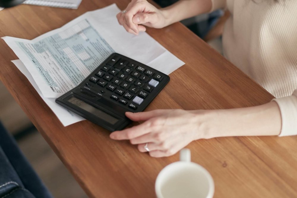 A woman calculating home value before long-distance moving 