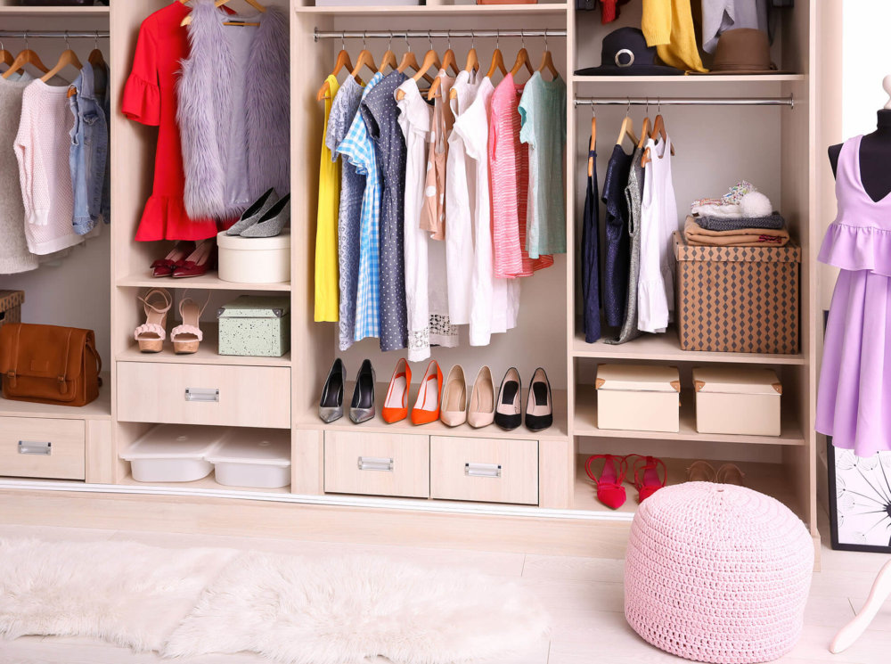 a colorful closet full of storing areas for clothes, shoes, and accessories