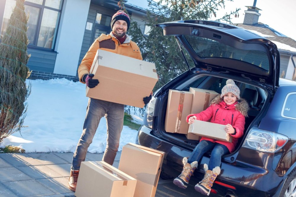 a father and daughter preparing for long-distance moving by packing their car