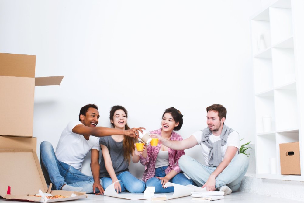 A group of friends eating together and toasting after cross-country moving