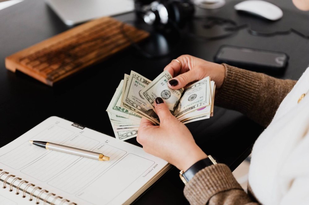 Woman counting money and going over the budget