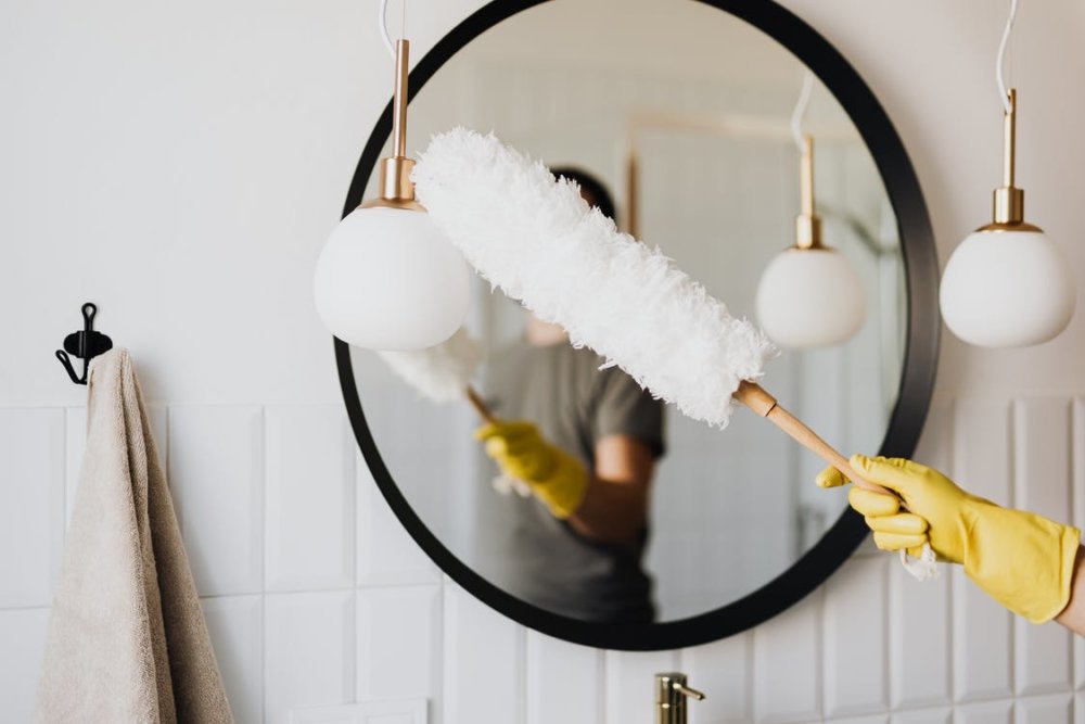 A man is dusting a lamp after cross country moving 