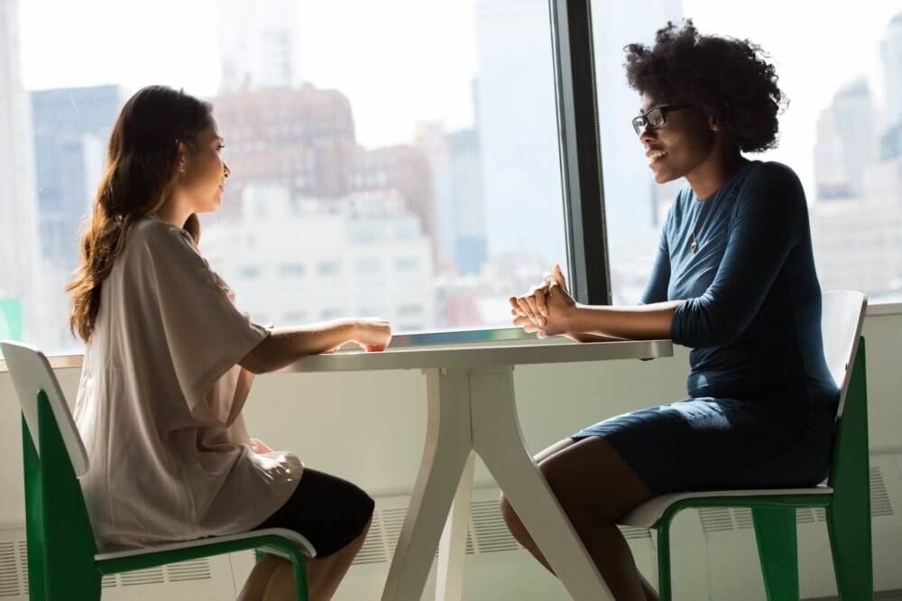 Two women talking about a car shipping company